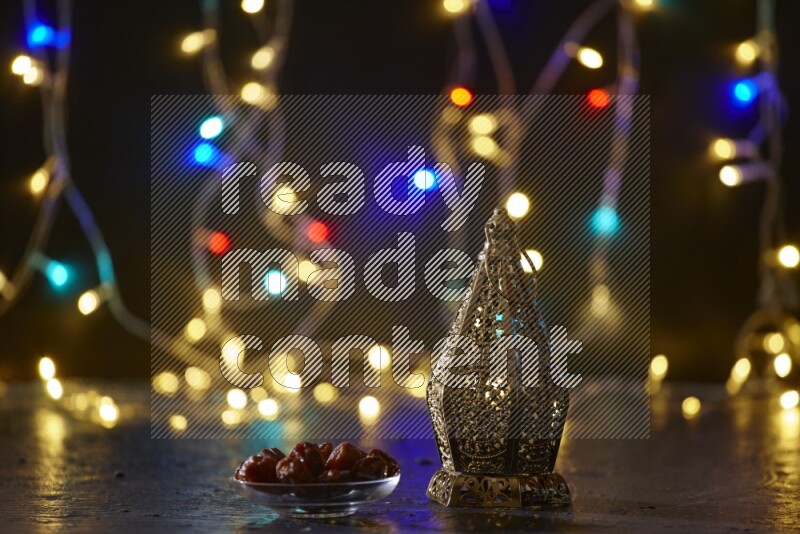 A traditional ramadan lantern surrounded by glowing fairy lights in a dark setup