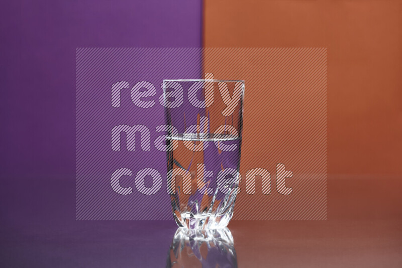 The image features a clear glassware filled with water, set against purple and dark orange background