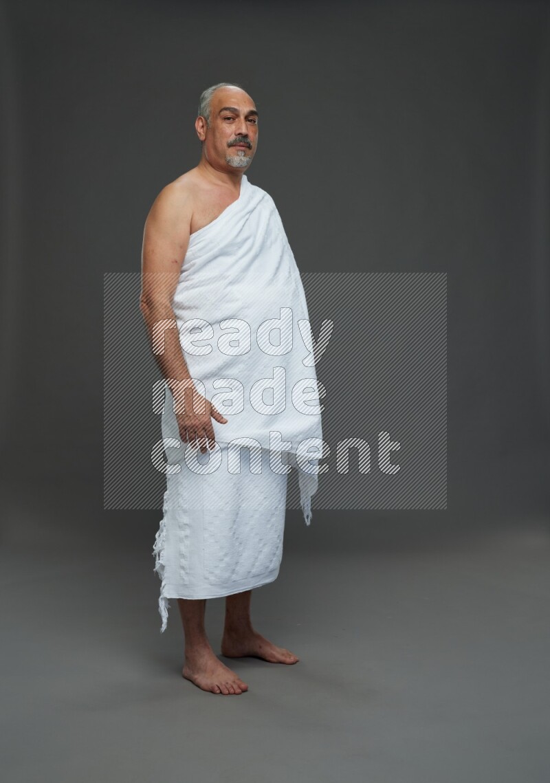 A man wearing Ehram Standing Interacting with the camera on gray background