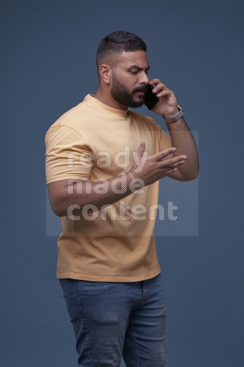 A man Calling on Blue Background wearing Orange T-shirt