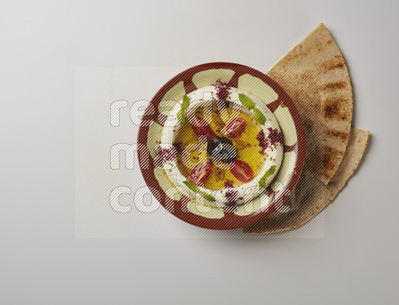 Lebnah garnished with Cherry tomato, mint & sumak  in a traditional plate on a white background