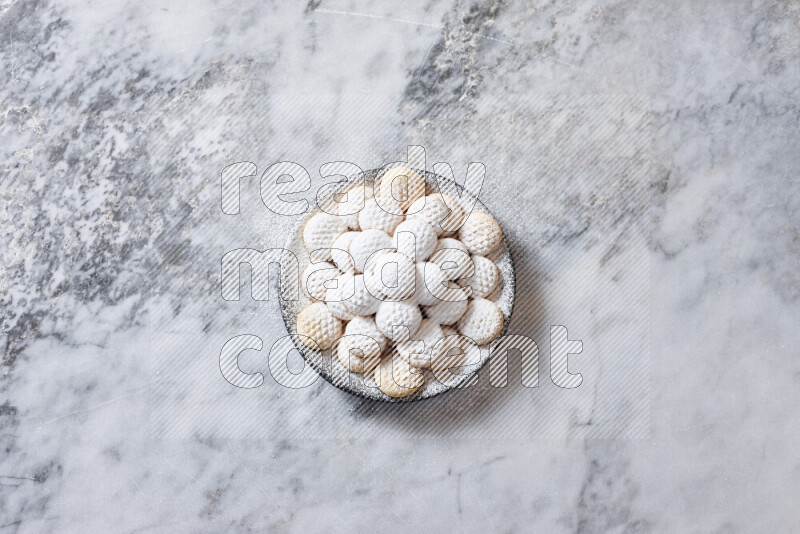 Kahk in black pottery plate on grey marble background