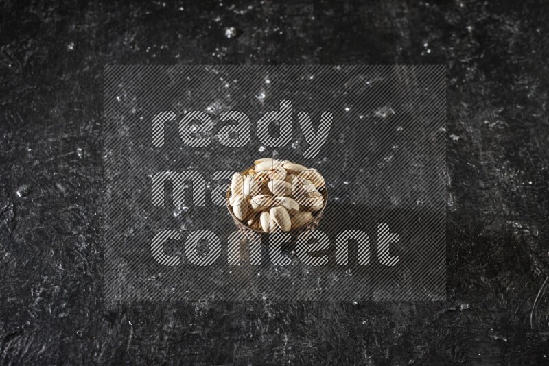 Nuts in a metal bowl in a dark setup