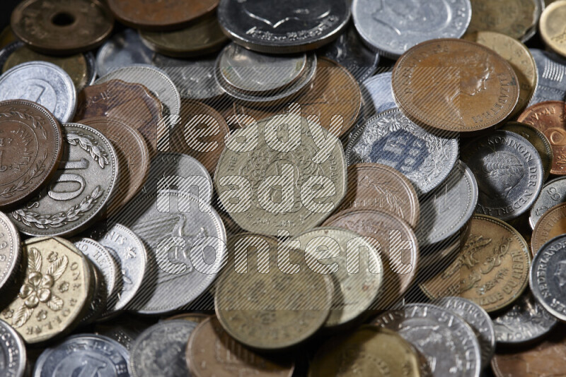 A close-ups of random old coins on black background