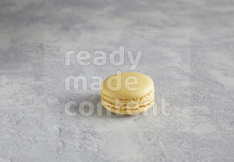 45º Shot of Yellow Vanilla macaron on white  marble background