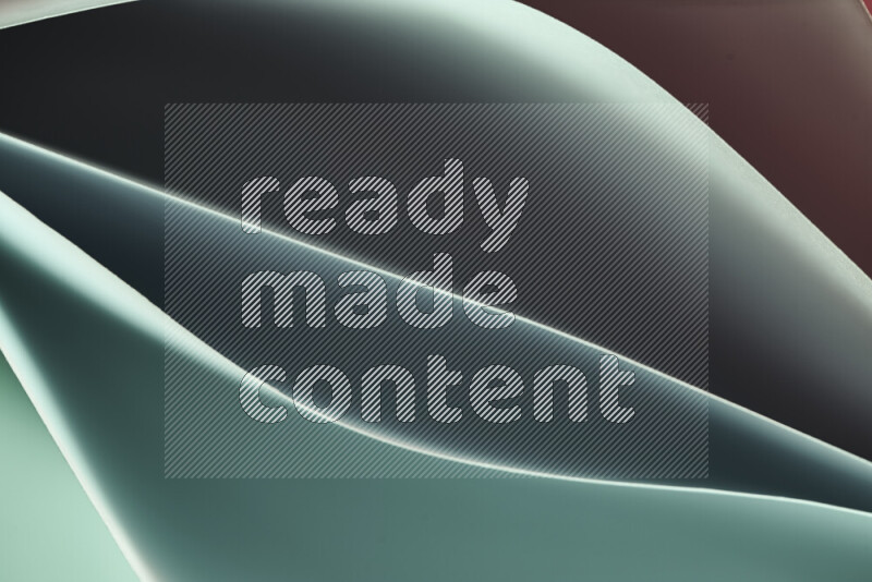 هذه الصورة تعرض تكوين فن الورق التجريدي مع منحنيات ورقية بتدرجات اللون الأخضر والأحمر المكونه بواسطة الضوء الملون