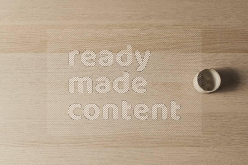 A pottery cup on light wooden background