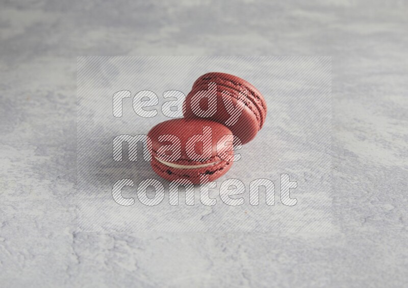 45º Shot of two Red Velvet macarons  on white  marble background