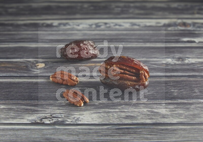two pecan stuffed madjoul date on a wooden grey background