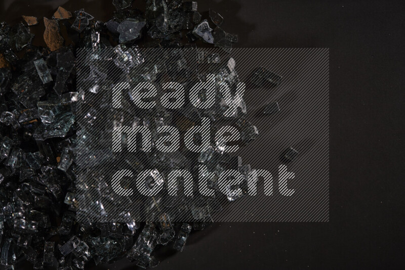Transparent black fragments of glass scattered on a black background
