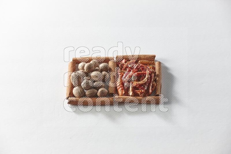 2 squares of cinnamon sticks full of dried red chilis and nutmegs on white flooring