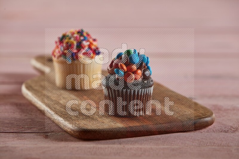 Chocolate mini cupcake topped with m&ms on a wooden board