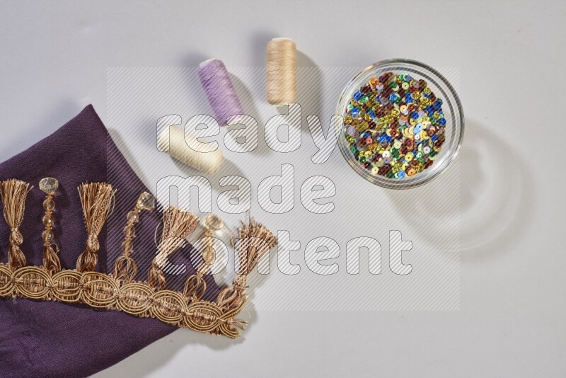 Multicolored fabrics with sewing supplies on grey background
