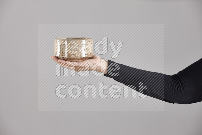 A woman in black abaya holding different pottery essentials in different positions
