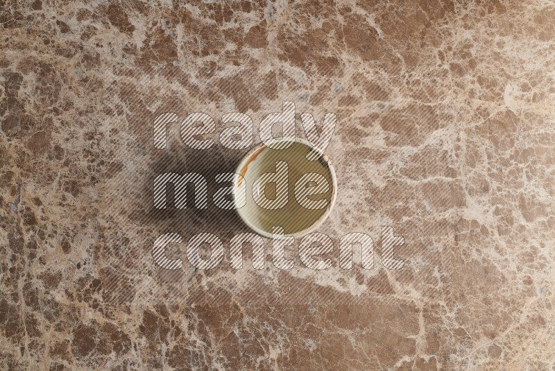 A white pottery bowl on beige marble background