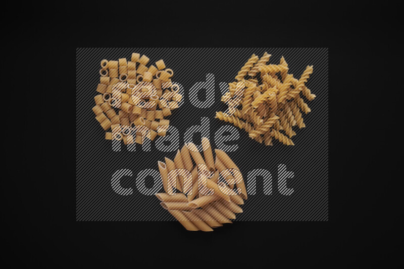 Different pasta types in bunches on black background
