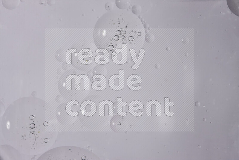 قطرات من الزيت على سطح الماء على خلفية بيضاء