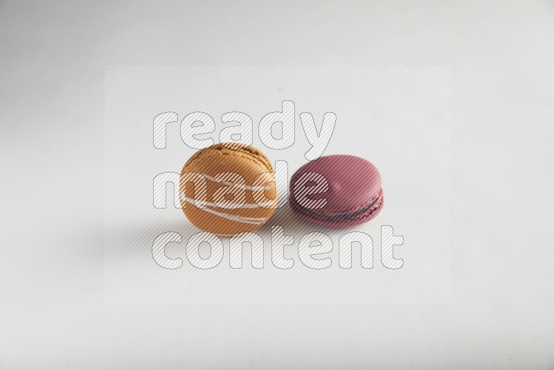 45º Shot of of two assorted Brown Irish Cream, and Red Cherry macarons on white background