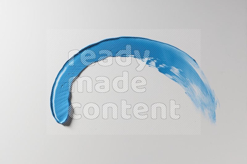 A blue single curved painting knife stroke on a white background