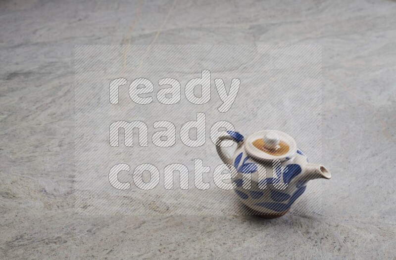 A pottery teapot on grey marble background