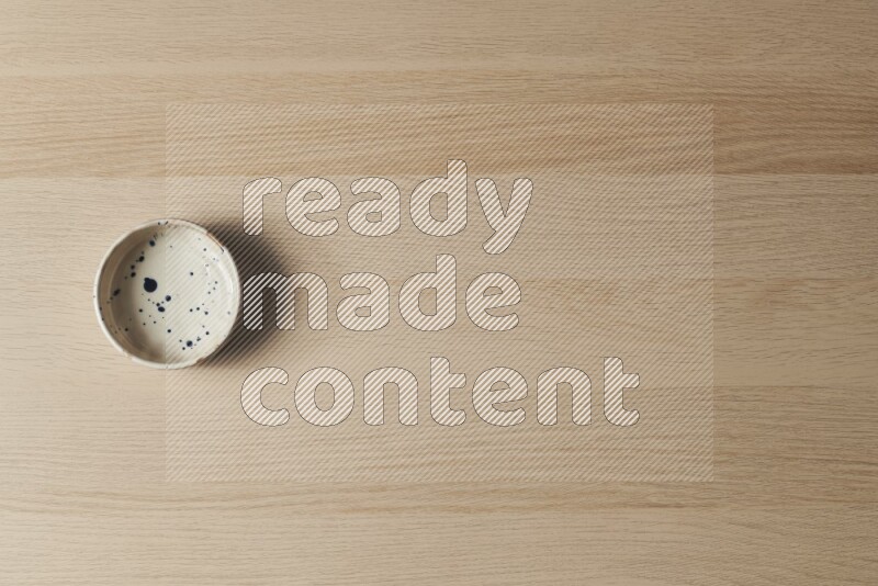 A multicolored pottery bowl on light wooden background