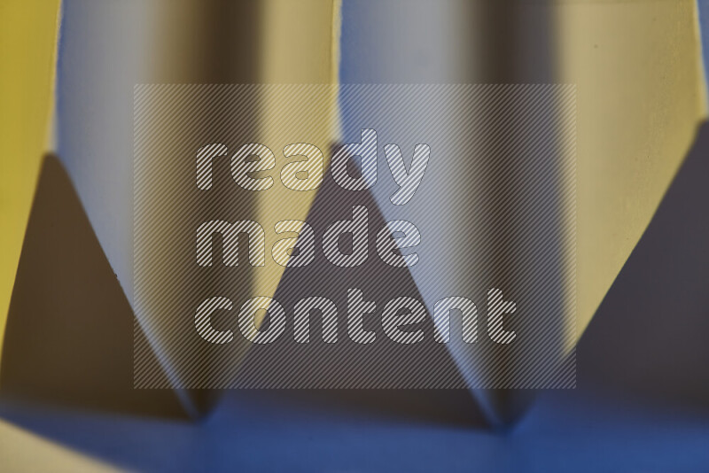 صورة مجردة مقربة تظهر طيات ورقية هندسية حادة بتدرجات اللون الأزرق مع درجات لونية دافئة