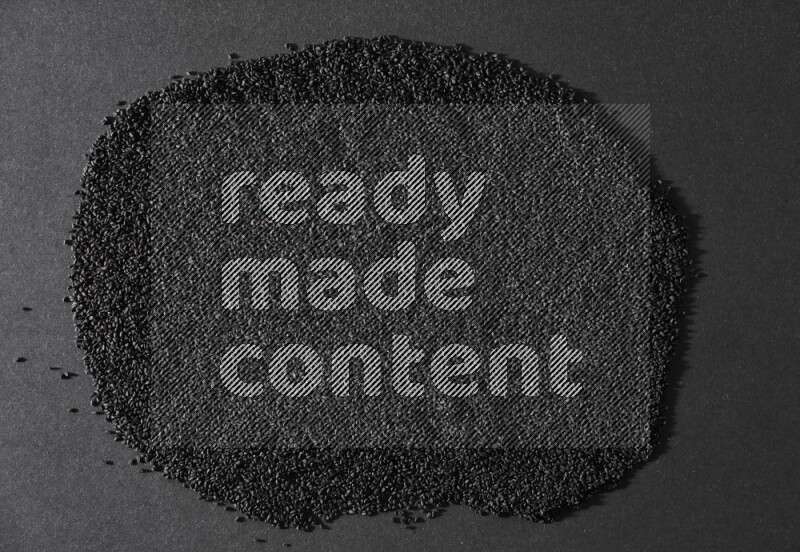 Black seeds filling the frame on a black flooring