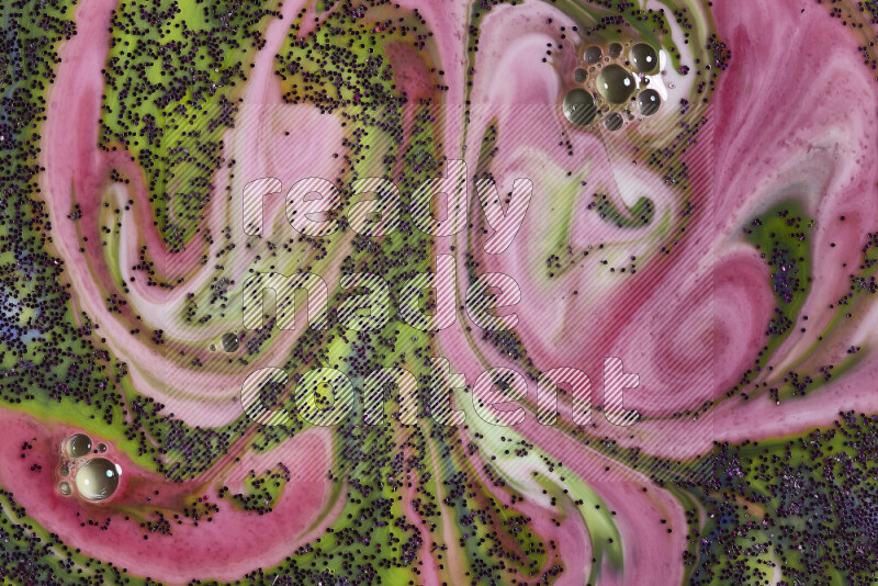 لقطة مقربة لبريق أرجواني متلألئ منتشر علي خلفية من اللون الأخضر والأحمر في حركات دائرية