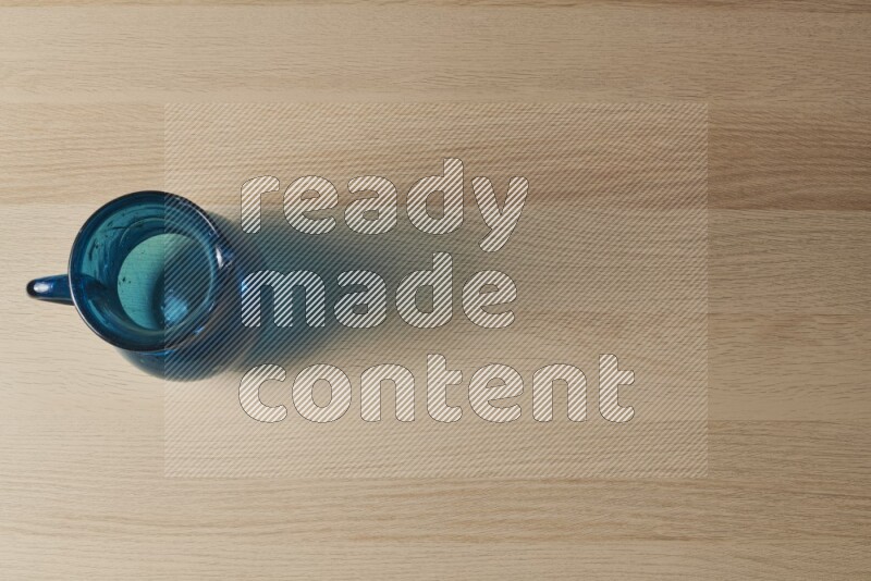 إبريق زجاجي فارغ على خلفية خشبية فاتحة