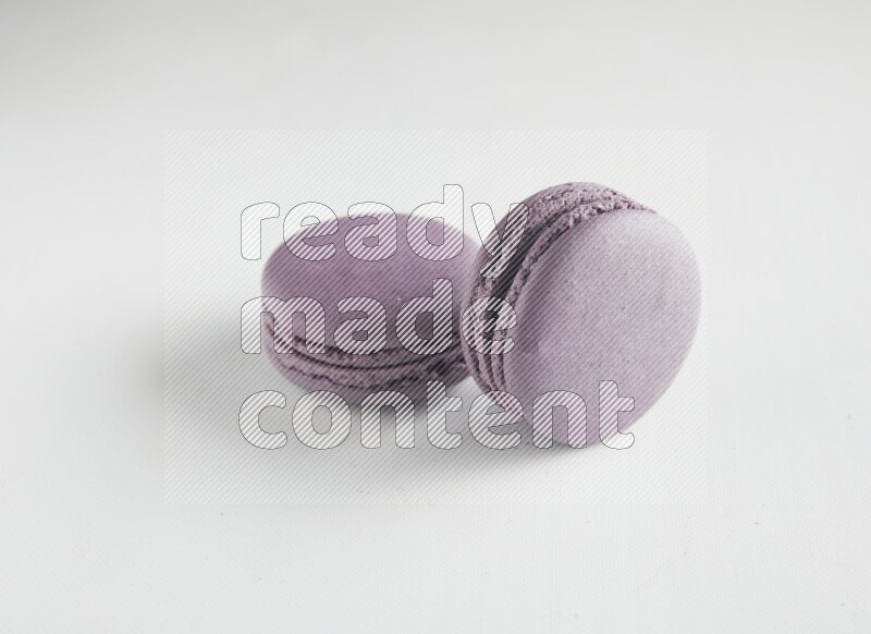 45º Shot of two Purple Blueberry macarons on white background