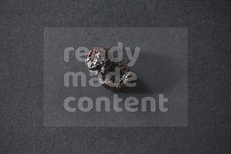 حبتان من البرقوق المجفف على خلفية سوداء