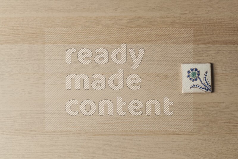 A decorative pottery coaster on light wooden background