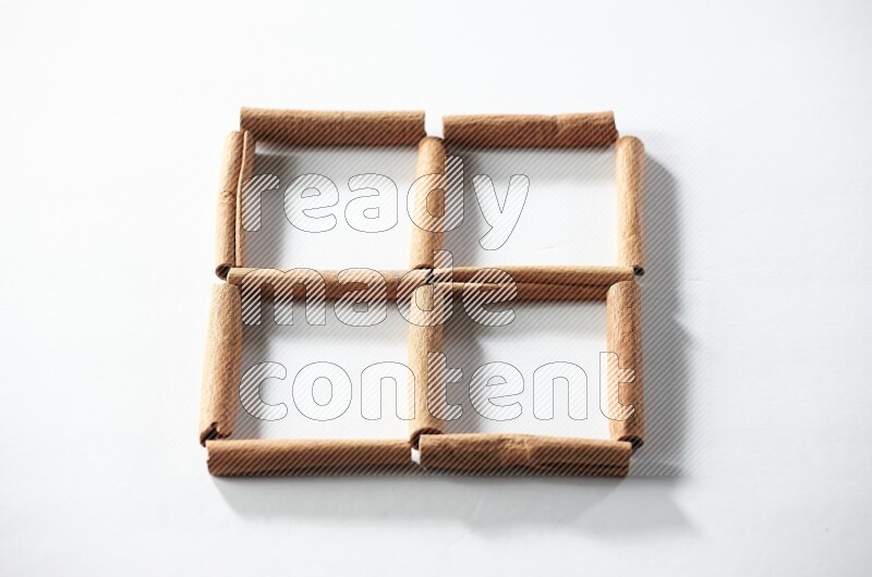 4 empty squares of cinnamon sticks on white flooring