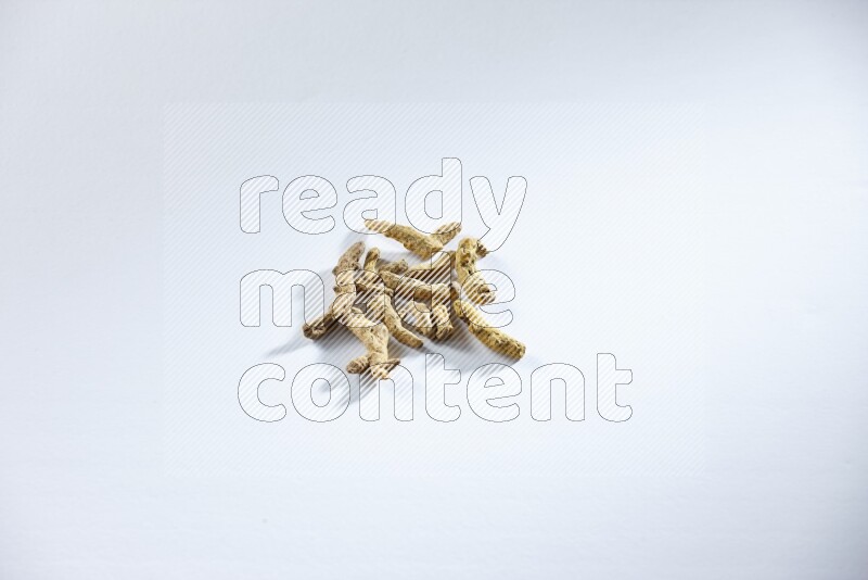 Dried turmeric whole fingers on white flooring