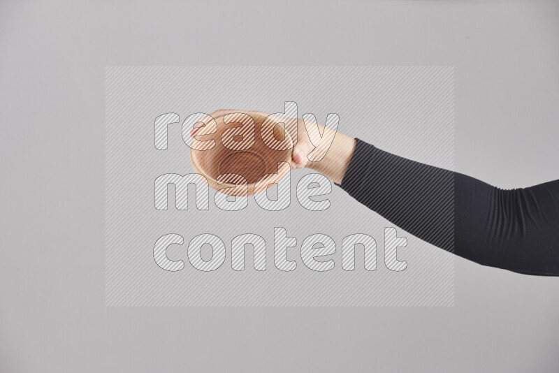 A woman in black abaya holding different wooden essentials in different positions
