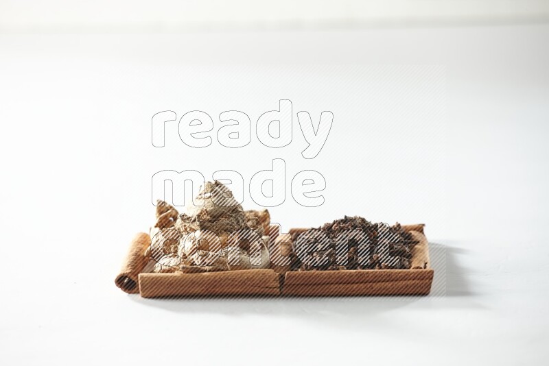 2 squares of cinnamon sticks full of cloves and dried ginger on white flooring
