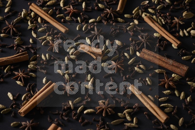 Cinnamon Sticks, Star anise, Cardamom and cloves on a black background