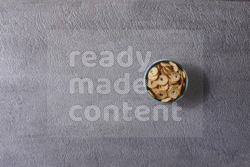 Assorted snacks in pottery bowls on grey background