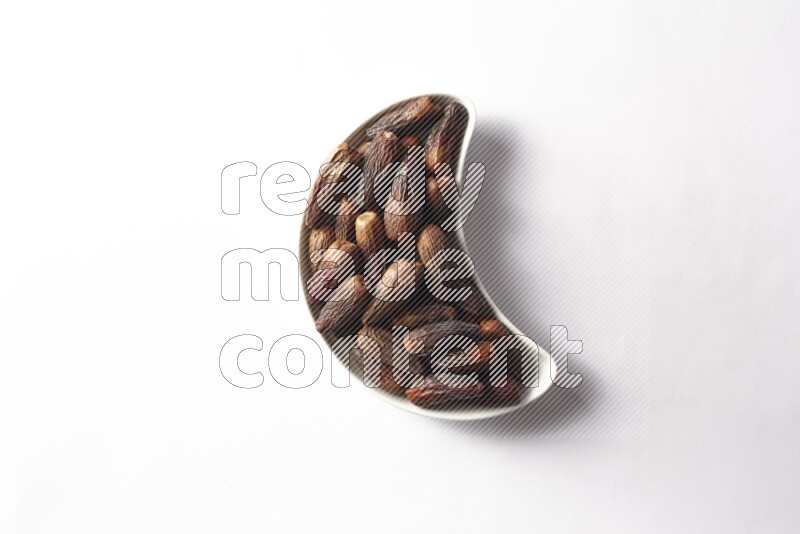 Dates in a crescent pottery plate on white background