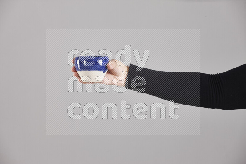 A woman in black abaya holding different pottery essentials in different positions