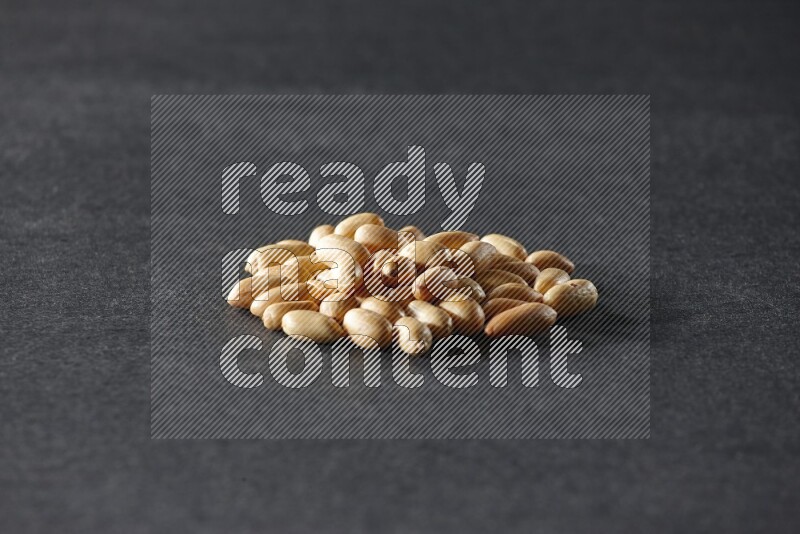 A bunch of peeled peanuts on a black background in different angles