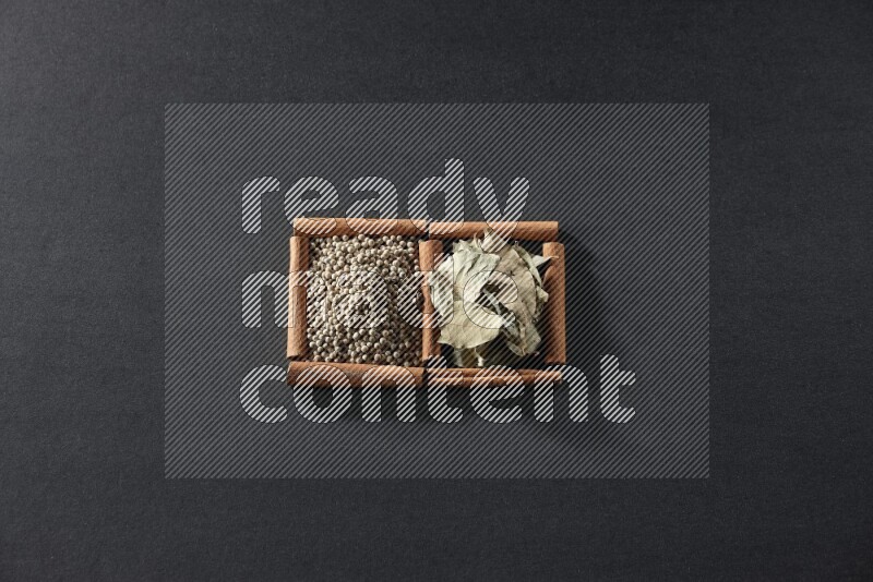 2 squares of cinnamon sticks full of white peppers and bay laurel leaves on black flooring