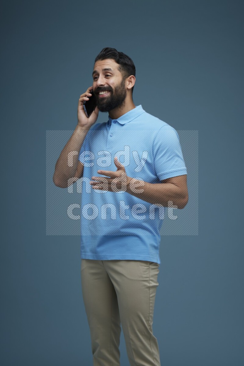 A man having a Call in a blue background wearing a Blue shirt