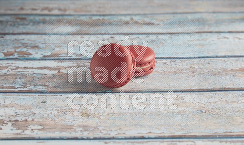 45º Shot of two Red Velvet macarons on light blue wooden background