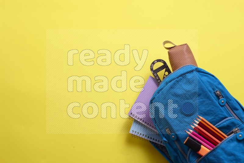 A blue school bag placed on yellow background