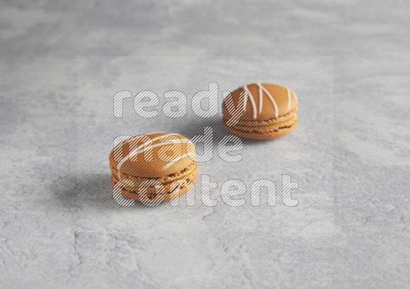 45º Shot of two Brown Irish Cream macarons  on white  marble background