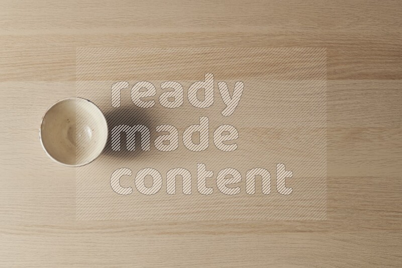 A white pottery bowl on light wooden background