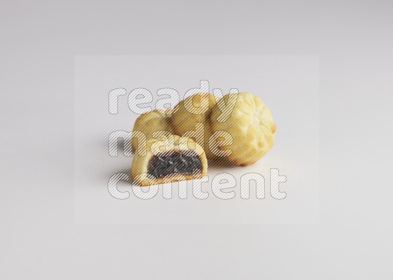 Four Pieces of Maamoul filled with date one of them is cut direct on white background