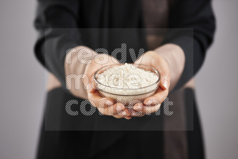 Woman in abaya holding different kinds of legumes in different positions