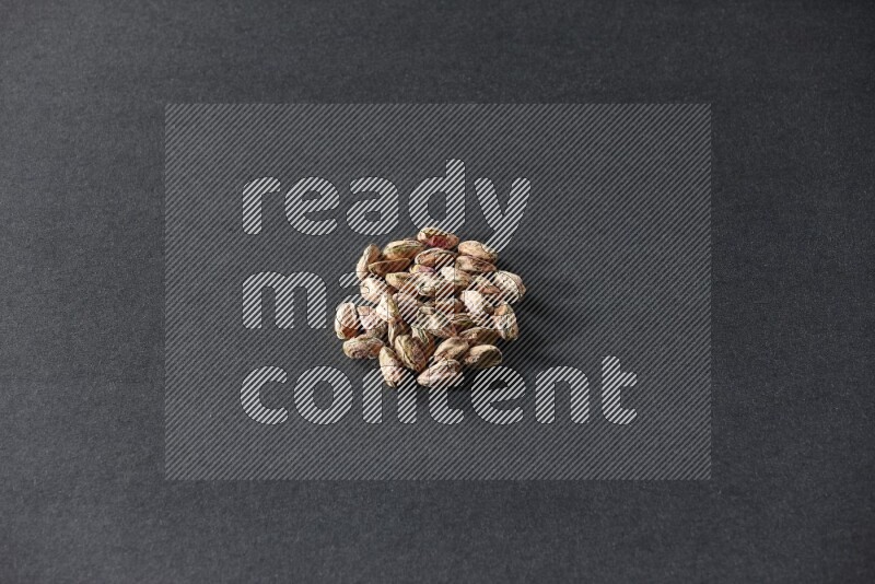 A bunch of peeled pistachios on a black background in different angles